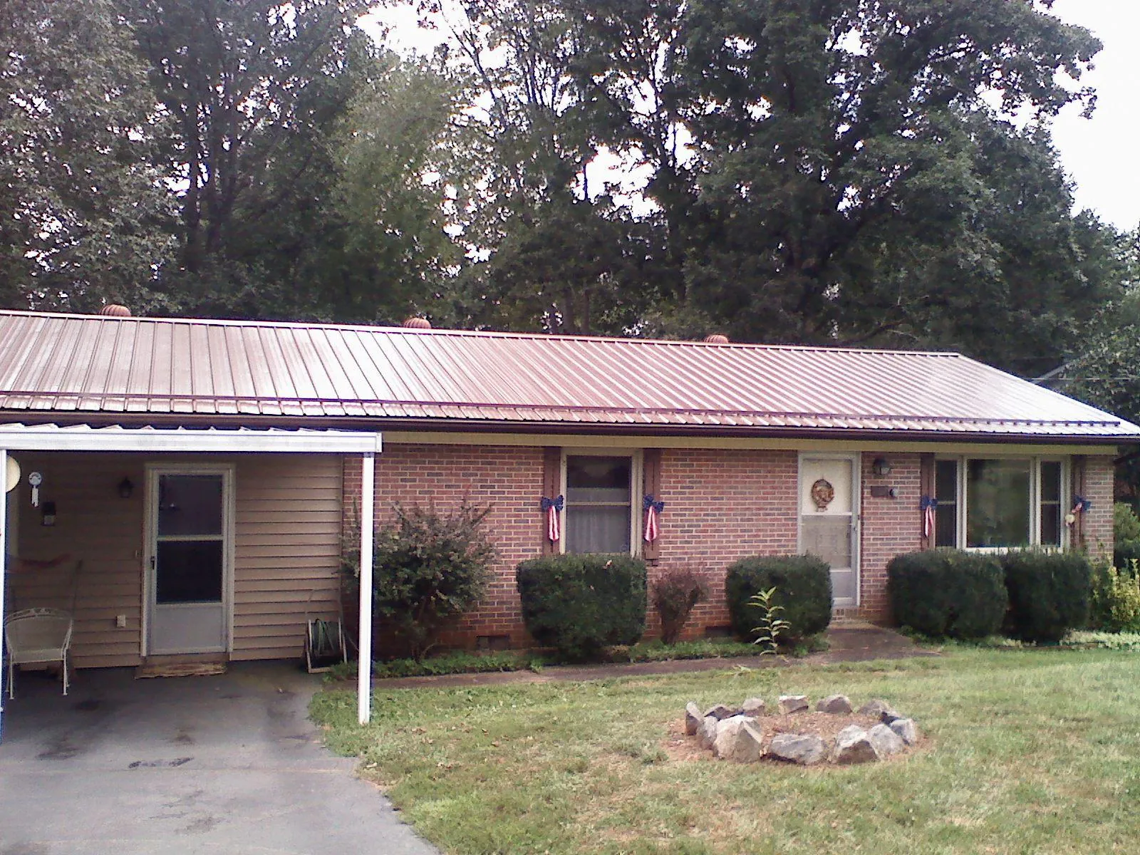Bronze metal roof and carport on a brick ranch home — Roof Repair work by our crew in New Palestine
